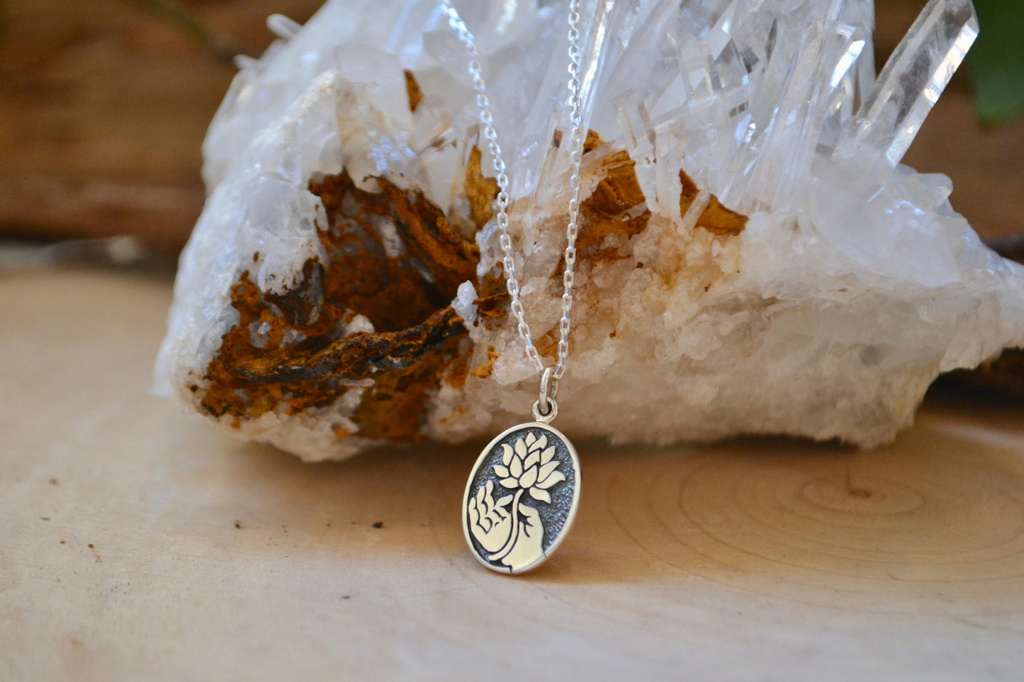 Hand holding lotus necklace