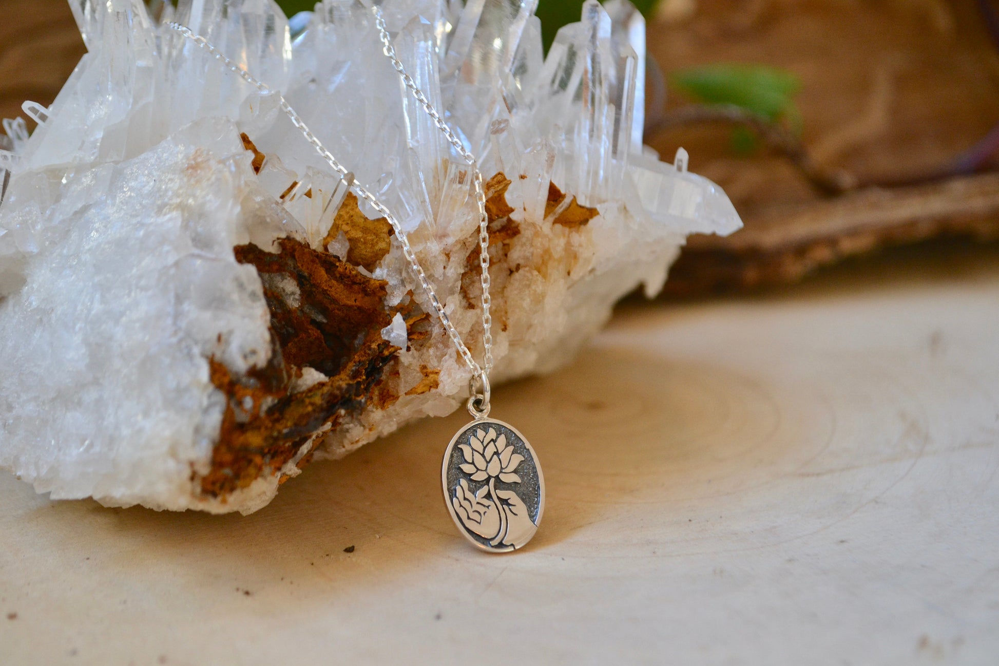 Hand holding lotus necklace